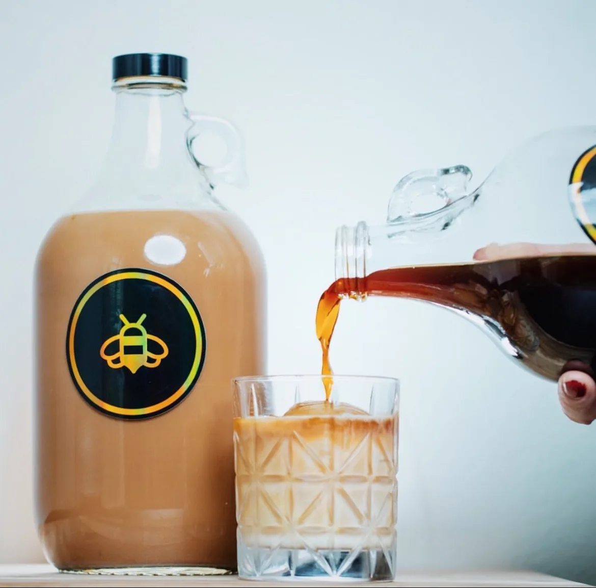 Half-gallon growler of Black Honey cold brew being poured over ice