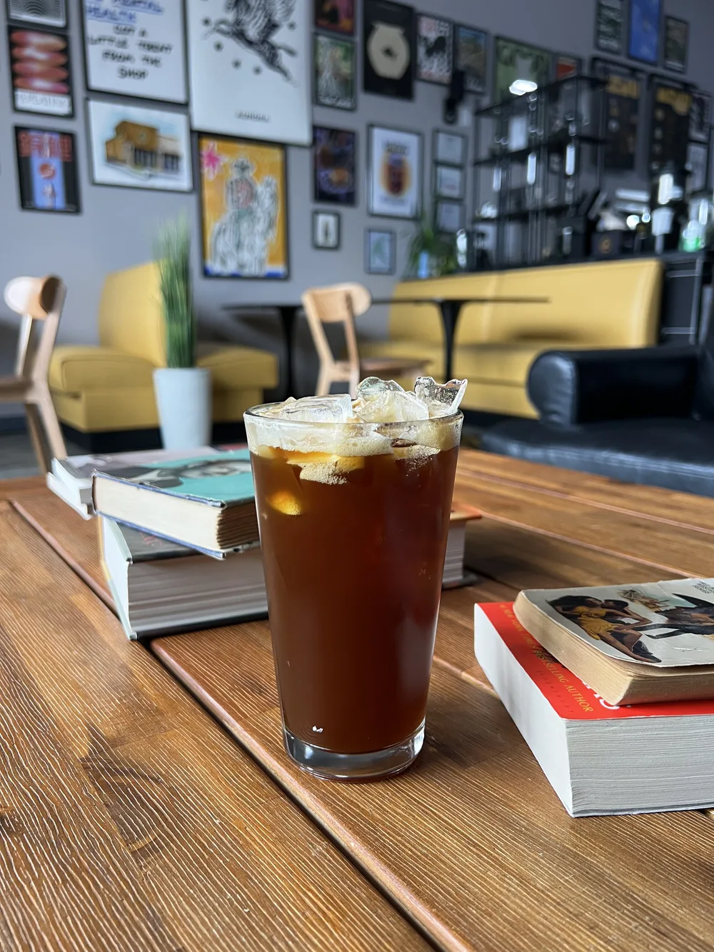 Iced coffee on a table with books inside the Black Honey shop