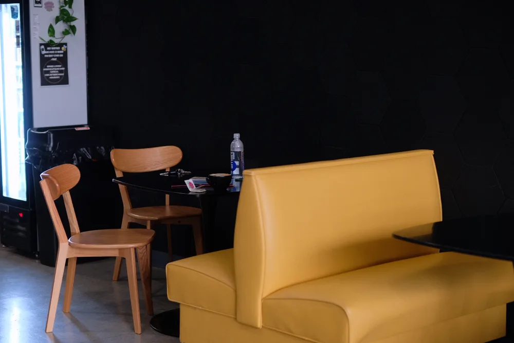 Yellow booth seating inside the Black Honey coffee shop